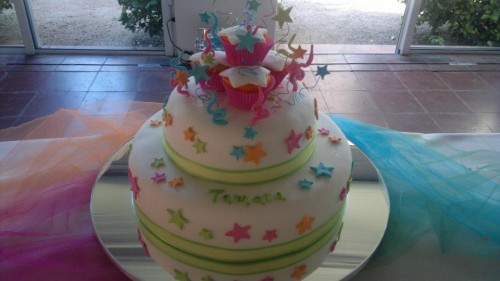 Muy colorida torta para quinceañera acompañada con divertidos cup cakes.